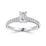 Harrogate Jewellers' Tapered Claw Set Emerald Cut Diamond Engagement Ring, featuring a central earth-mined diamond, accentuated with a row of smaller diamonds in a platinum band.